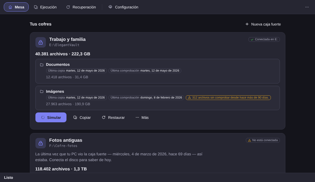 Mesa de Elegant Vault: la tarjeta de la caja fuerte Trabalho e família, conectada en E:, con 40.381 archivos y 222,3 GB, las carpetas protegidas con su última copia y su última comprobación, y el aviso en ámbar de 312 archivos sin comprobar desde hace más de 90 días